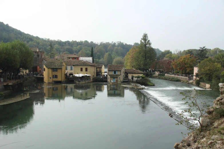 a river runs through a village near a forest