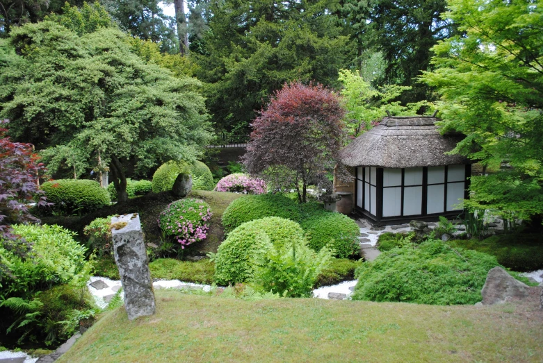 an oriental garden with a gazebo and stream running through the trees
