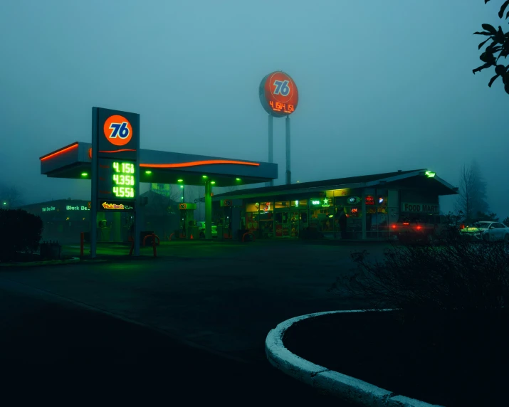 a gas station with a lighted sign sitting next to it