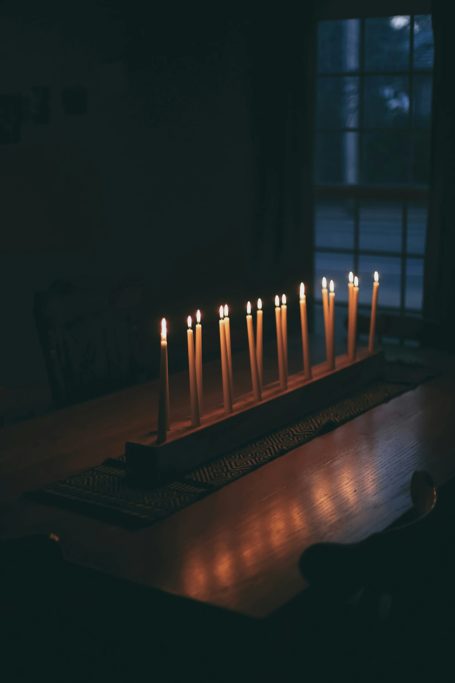 a row of lit candles sitting on top of a table