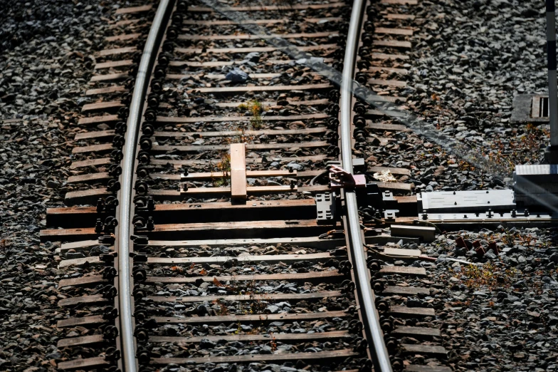 railroad tracks and the end part of a small container car