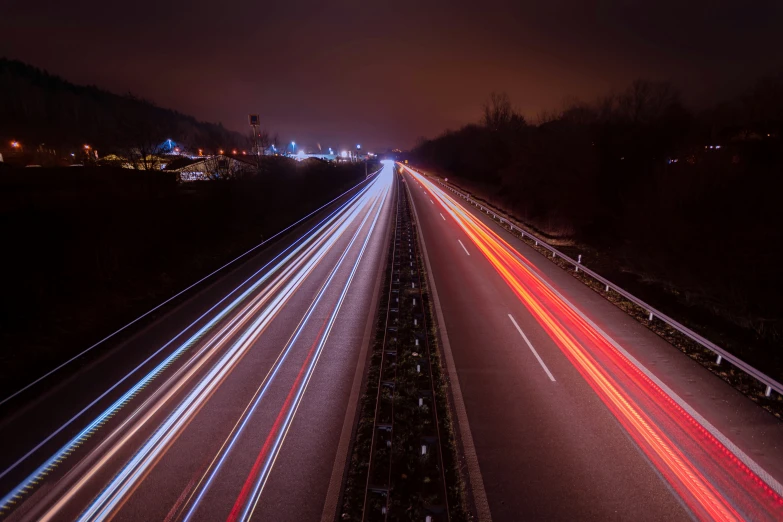 several cars are driving down the road at night