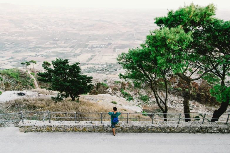 a man stands on the top of the hill watching the scenery