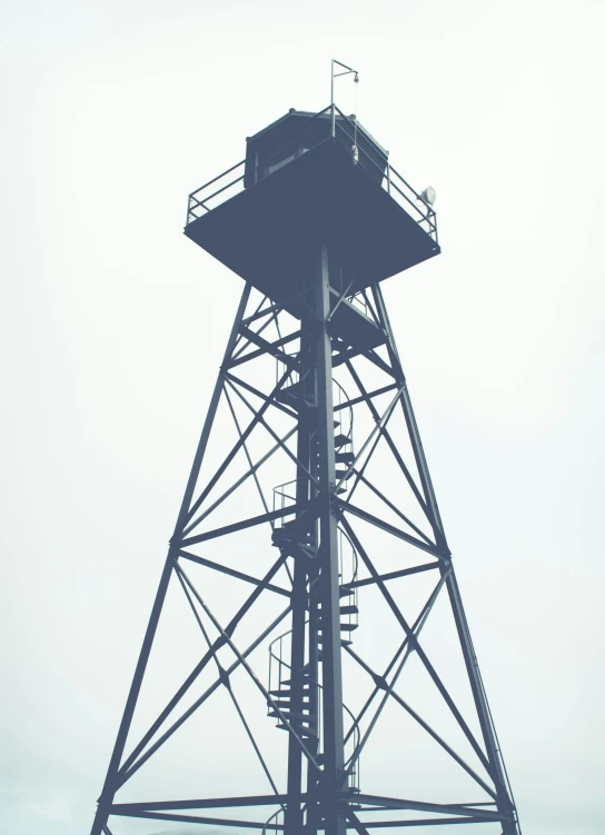 a tall tower with two stairs and a wind indicator on it