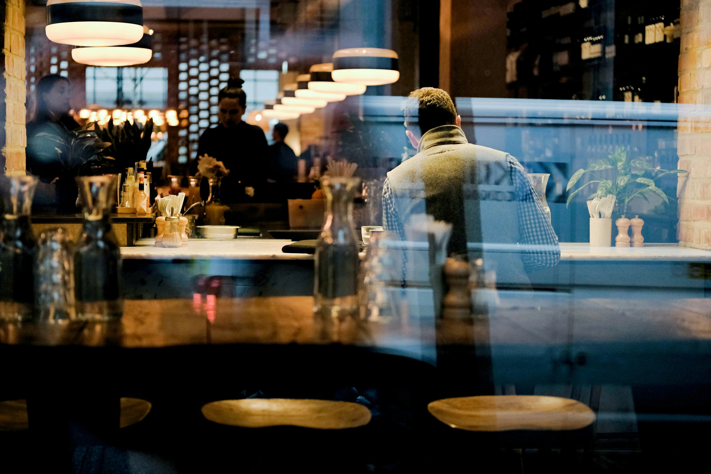 a man sitting at a restaurant table in the rain