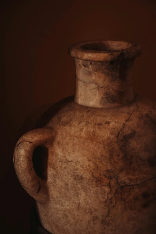 a dirty old vase that is sitting in a dark room