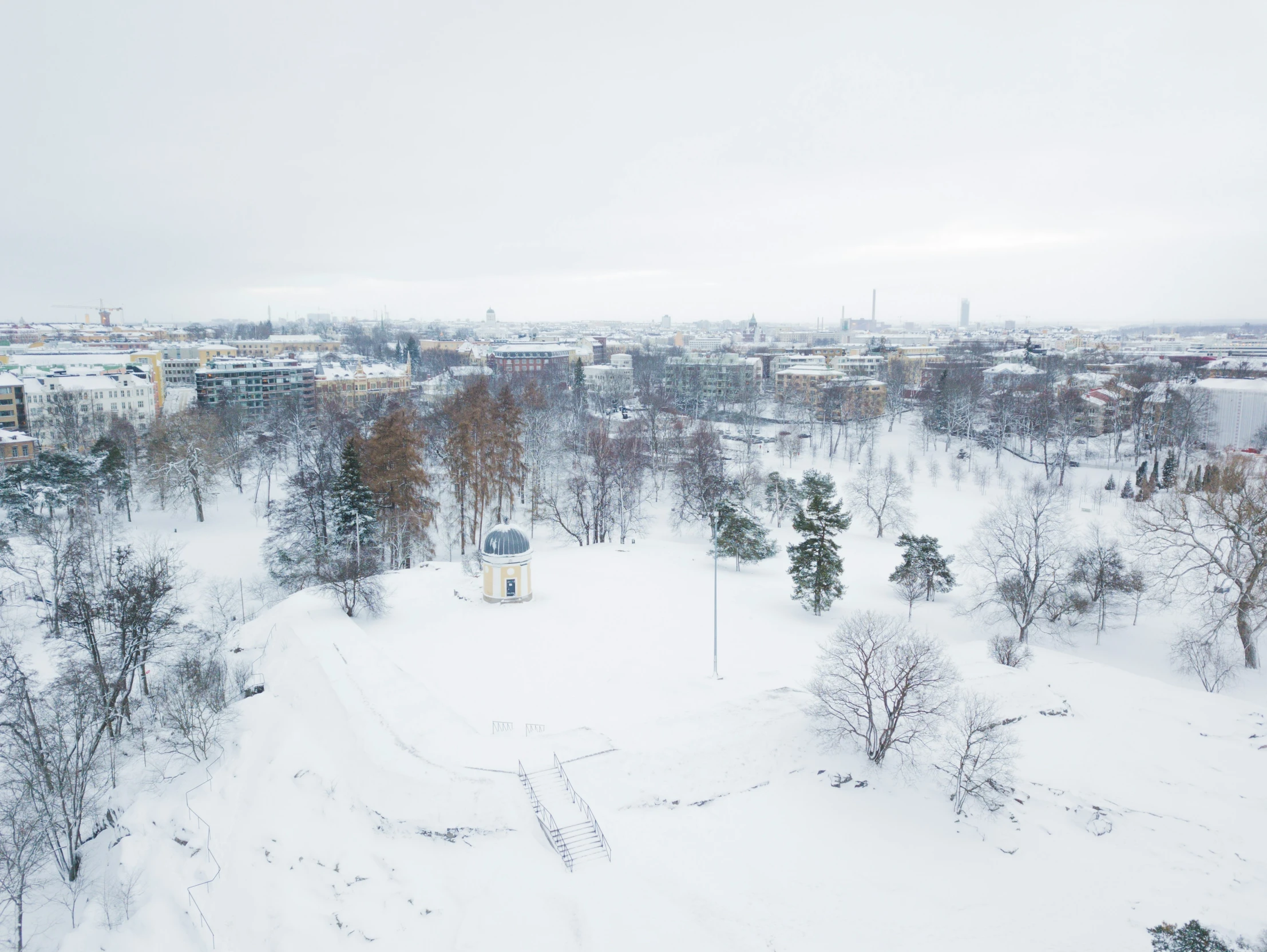 snowy city with a clock tower in the center