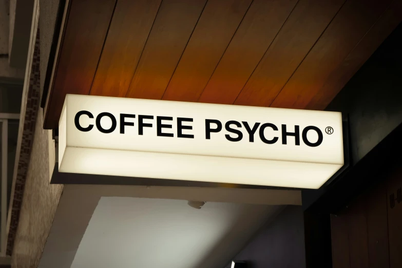 coffee sign lit up underneath the wooden ceiling