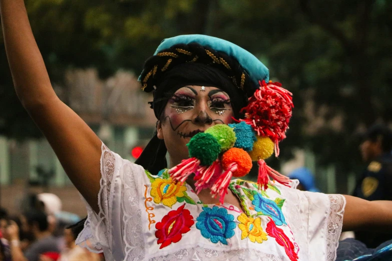 a woman in a colorful costume holding up a cell phone