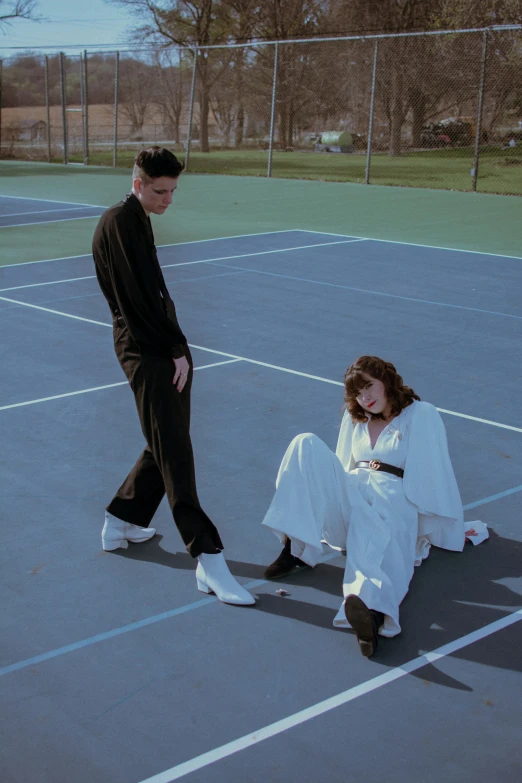 two people stand on a tennis court