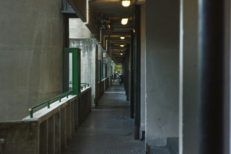 a building corridor that is empty and has green dividers on both sides