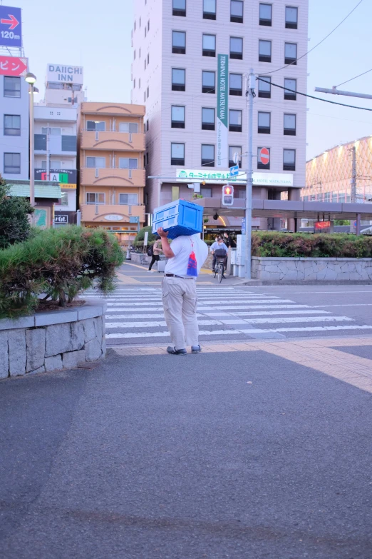 a woman on a street holding a blue and red umbrella