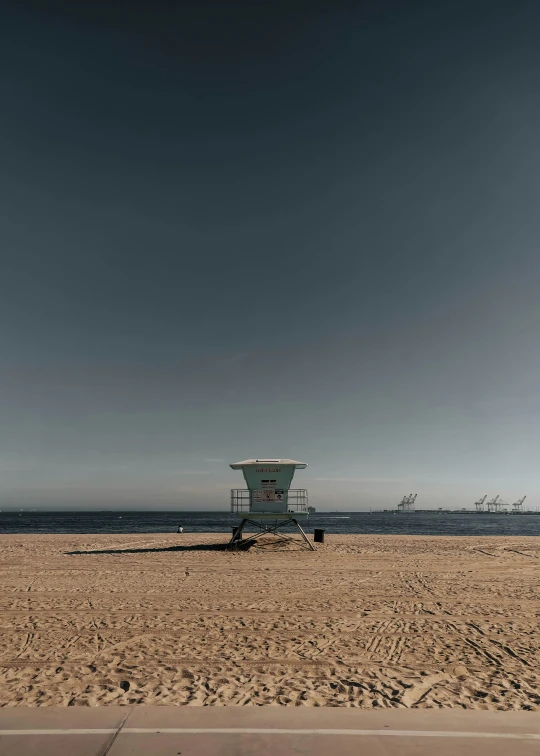 there is a bench and a lifeguard tower on a beach