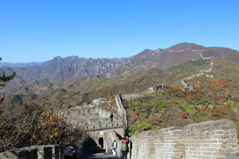 a large stone wall with some hills in the background