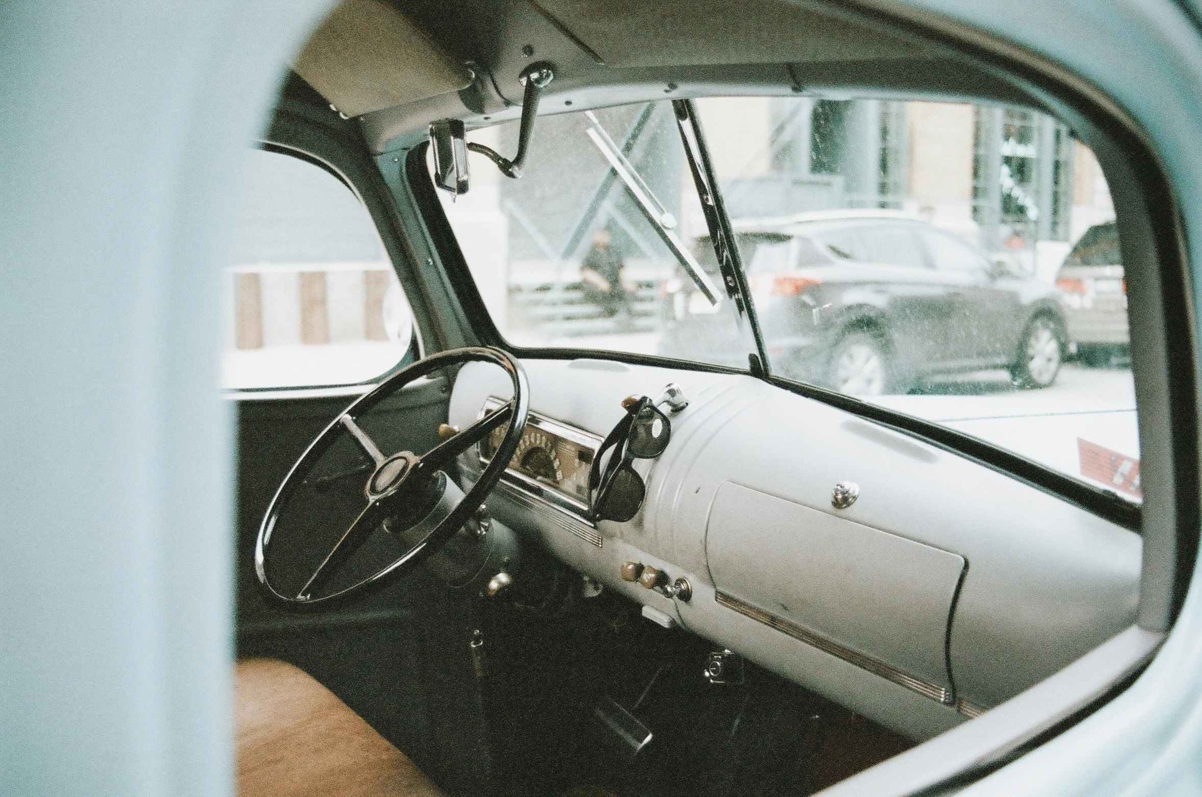 an old white car's interior is seen through the window