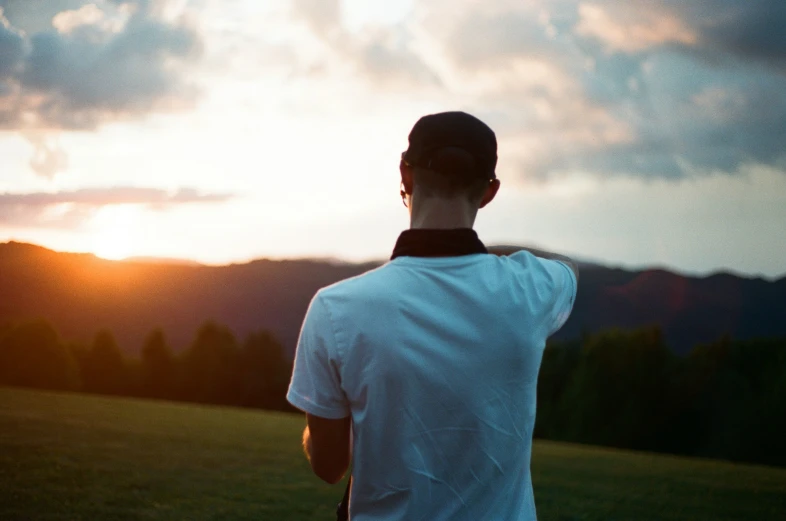 a man looks at the sky over a hill