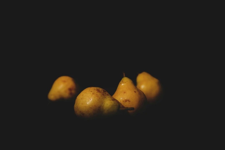 a group of three pears sit on a table