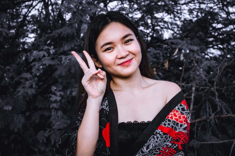 a woman in a red and black dress holding up two fingers