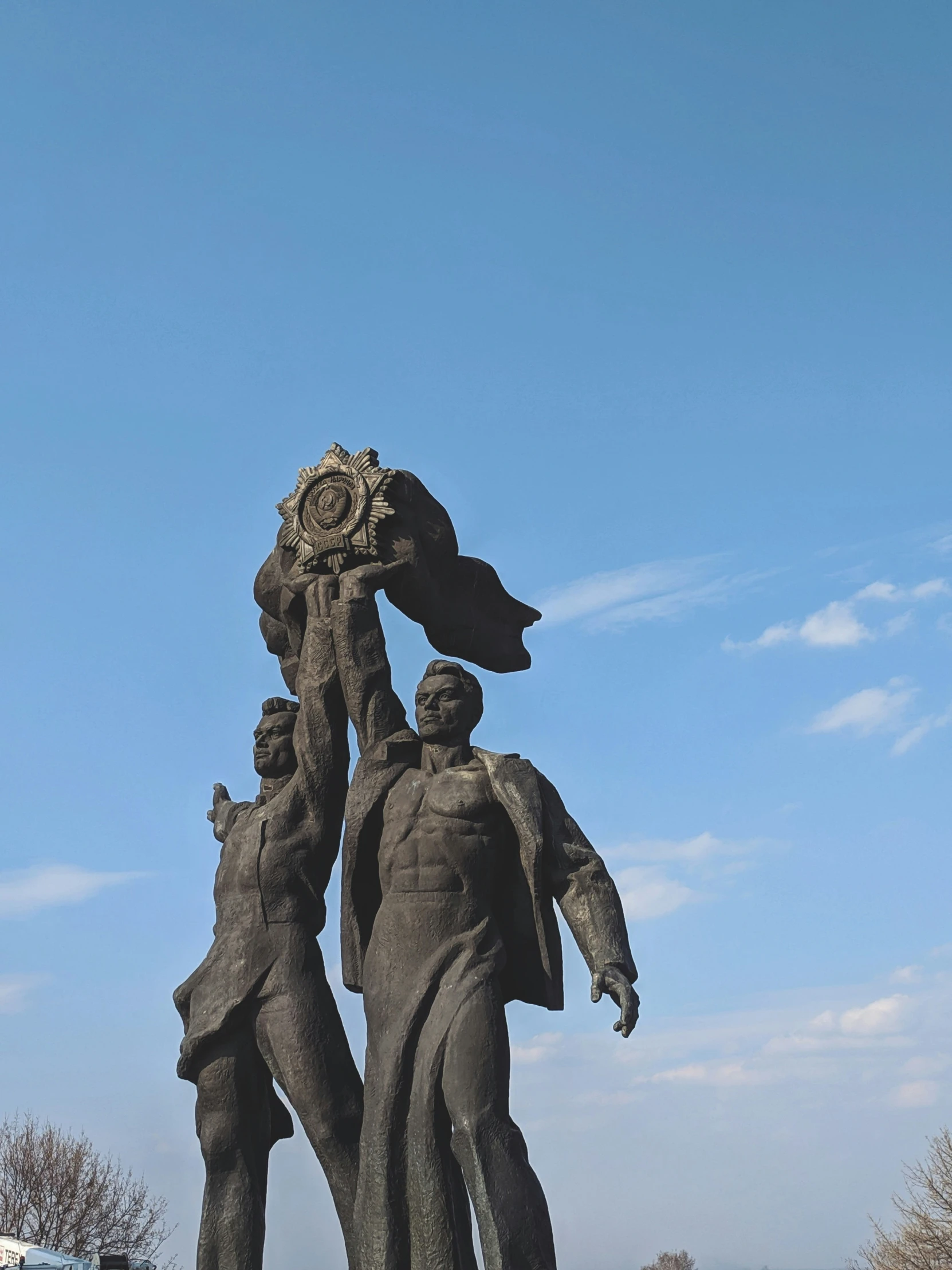 a tall statue of two men carrying flowers