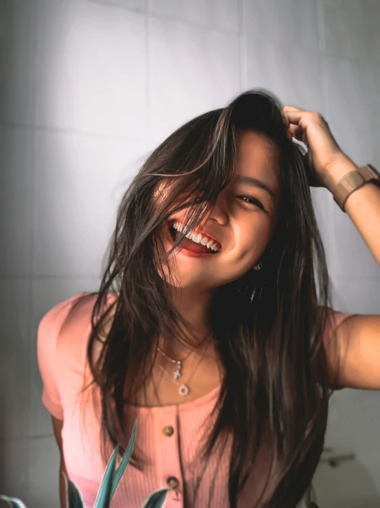 woman with long dark hair smiling in the bathroom