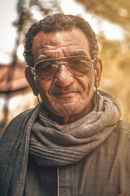 an elderly man in sunglasses looks to the camera