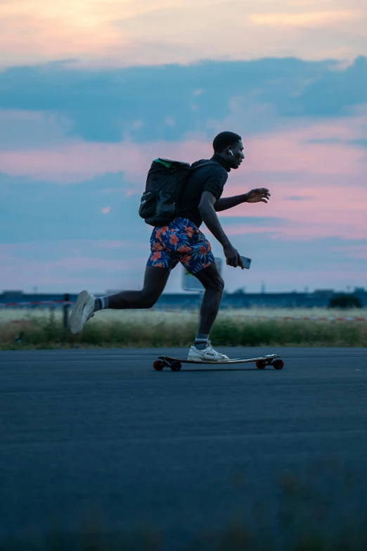 a man is skating down the street at dusk