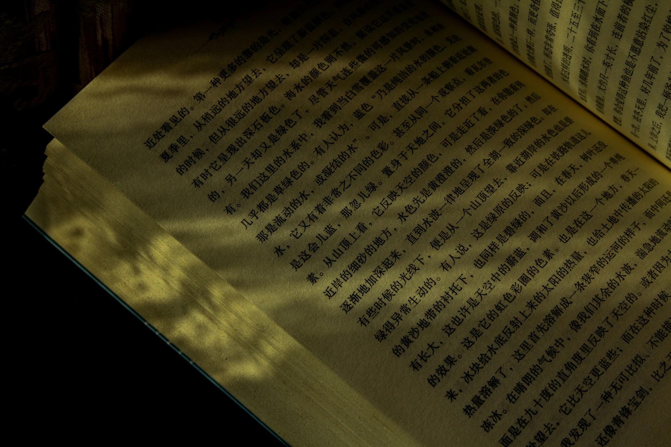 a shadow of a clock is cast onto an open book