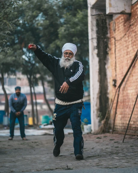 a man in a turban throwing a frisbee while another man watches him
