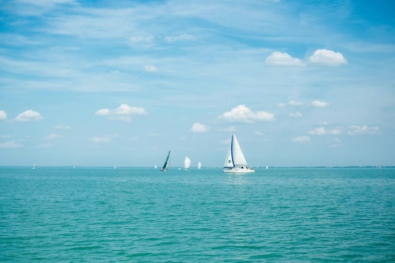 sailboats in the water on a cloudy day