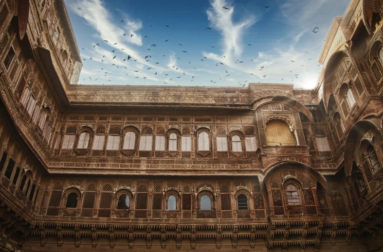 birds flying through the blue sky above a building