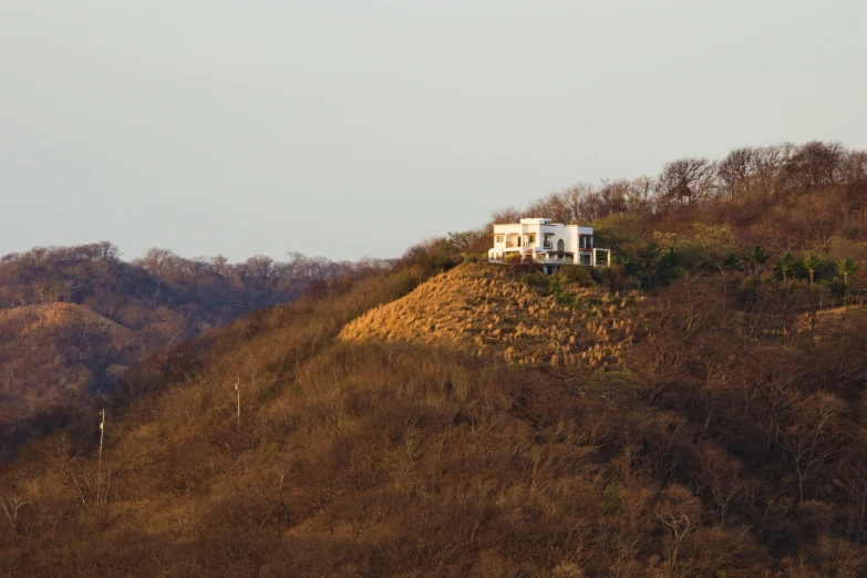 a house on a hill covered in dry grass