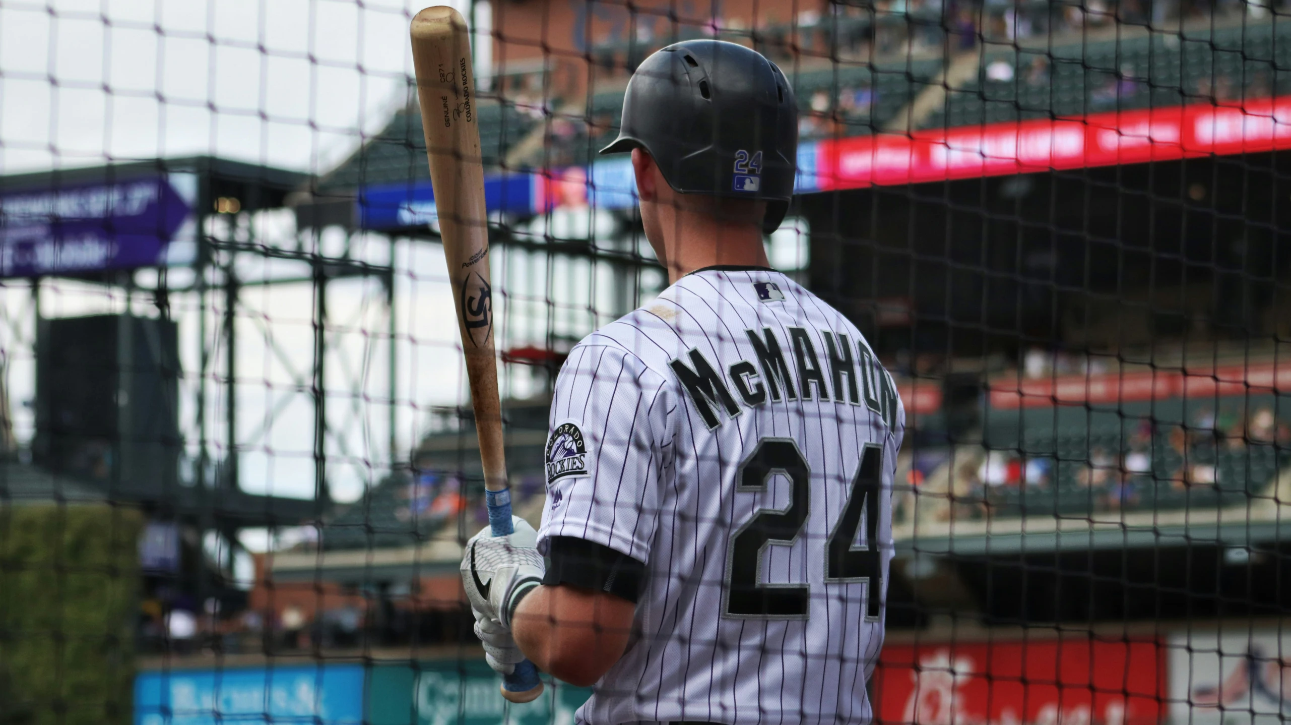 the baseball player looks up in a stadium with his bat