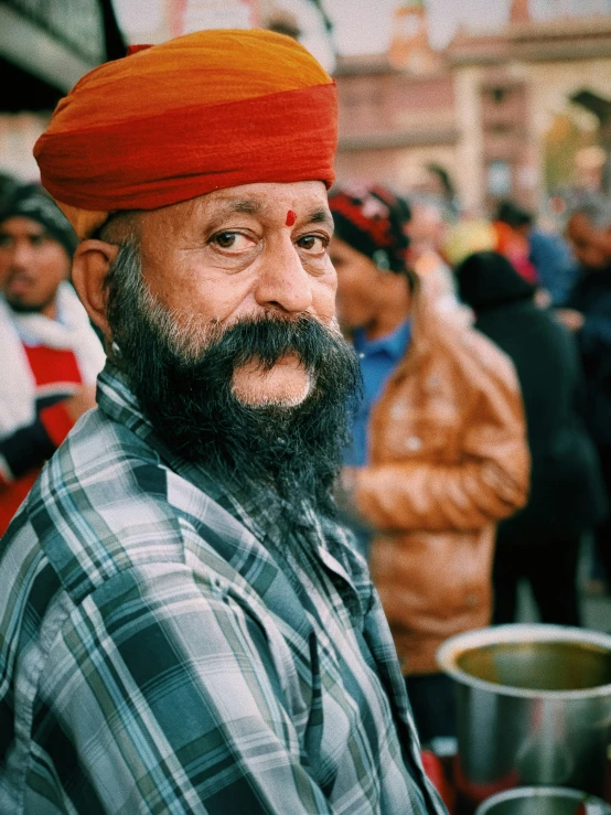 a man with a beard and an orange turban