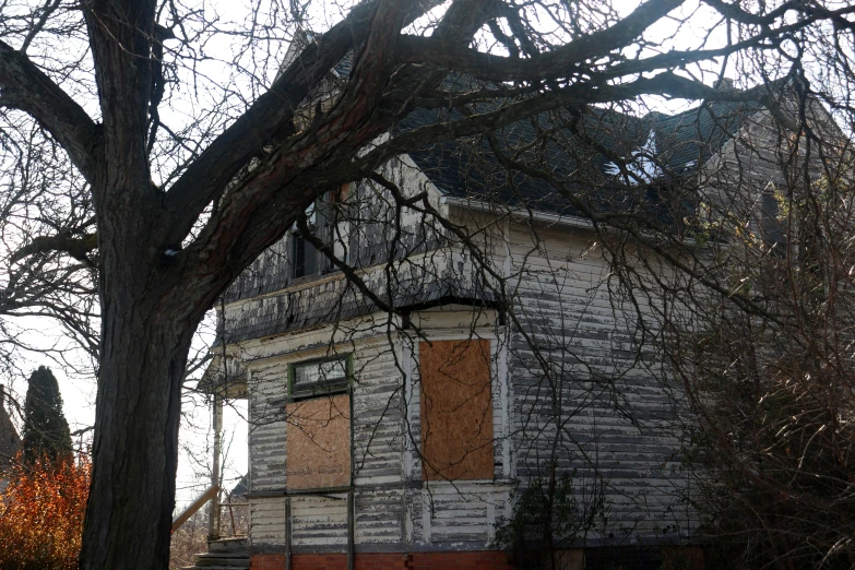 a dilapidated house with brown doors and window shutters