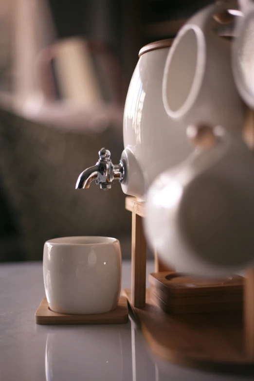 a white cup and faucet on a table