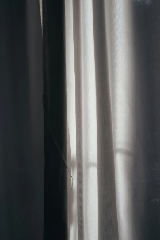 some silver colored curtain fabric in front of a window