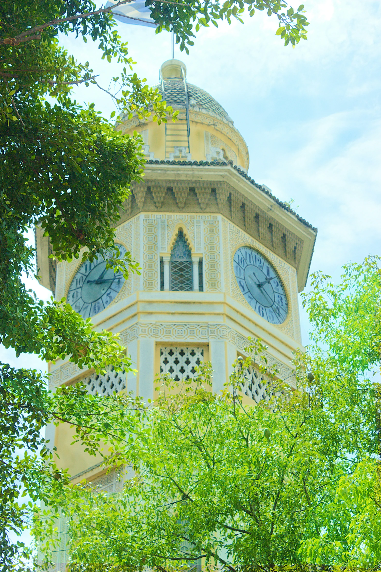 a white and yellow clock tower with a circular window