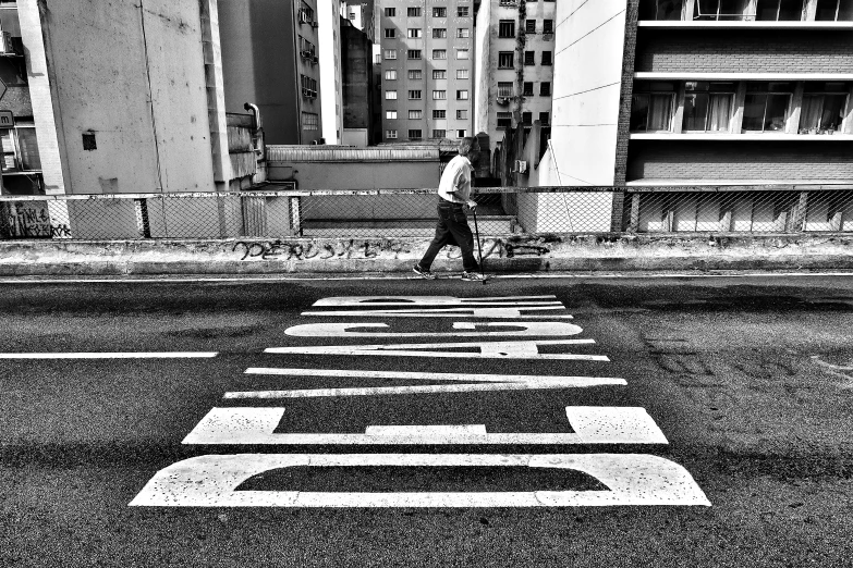 the man walking across the street is crossing the crosswalk