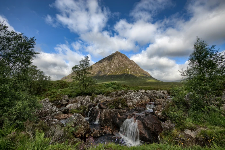 a small waterfall cascades down a rocky hillside