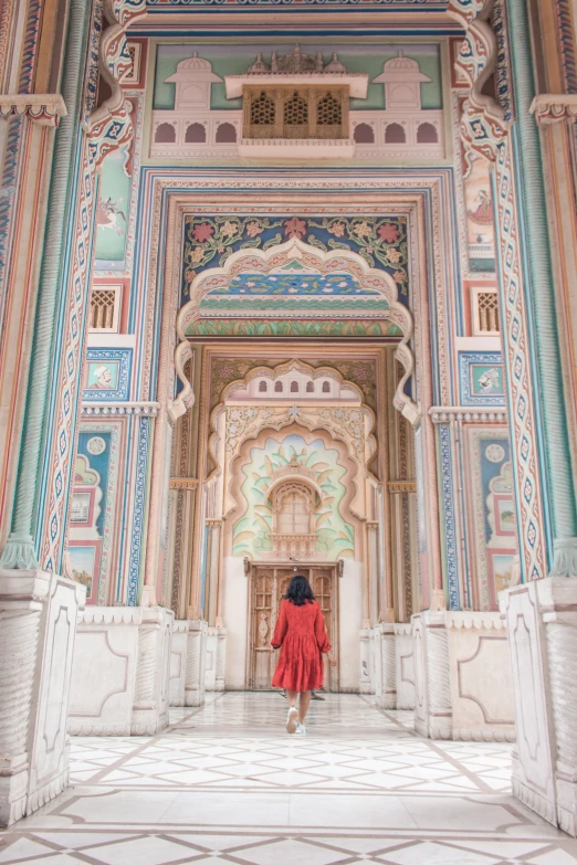 a woman is walking through the ornate archway