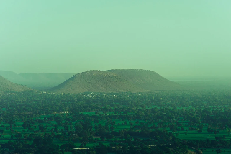 a grassy valley sits at the foot of a large mountain