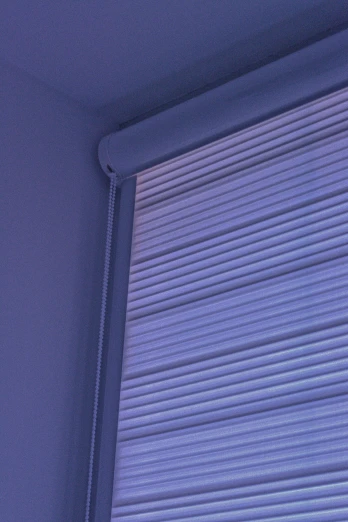 the side of a window with an opened roll of blinds