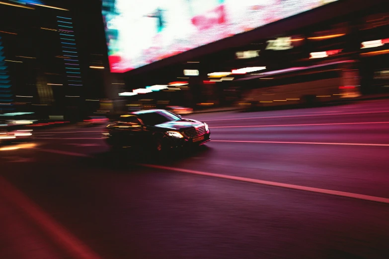 the car driving down a street is blurred and blurry