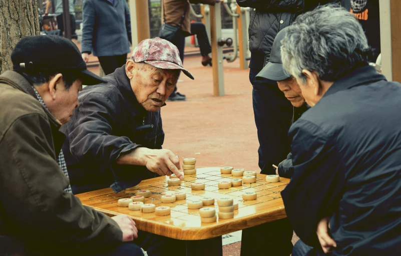 an elderly man playing a board game of chinese checkers