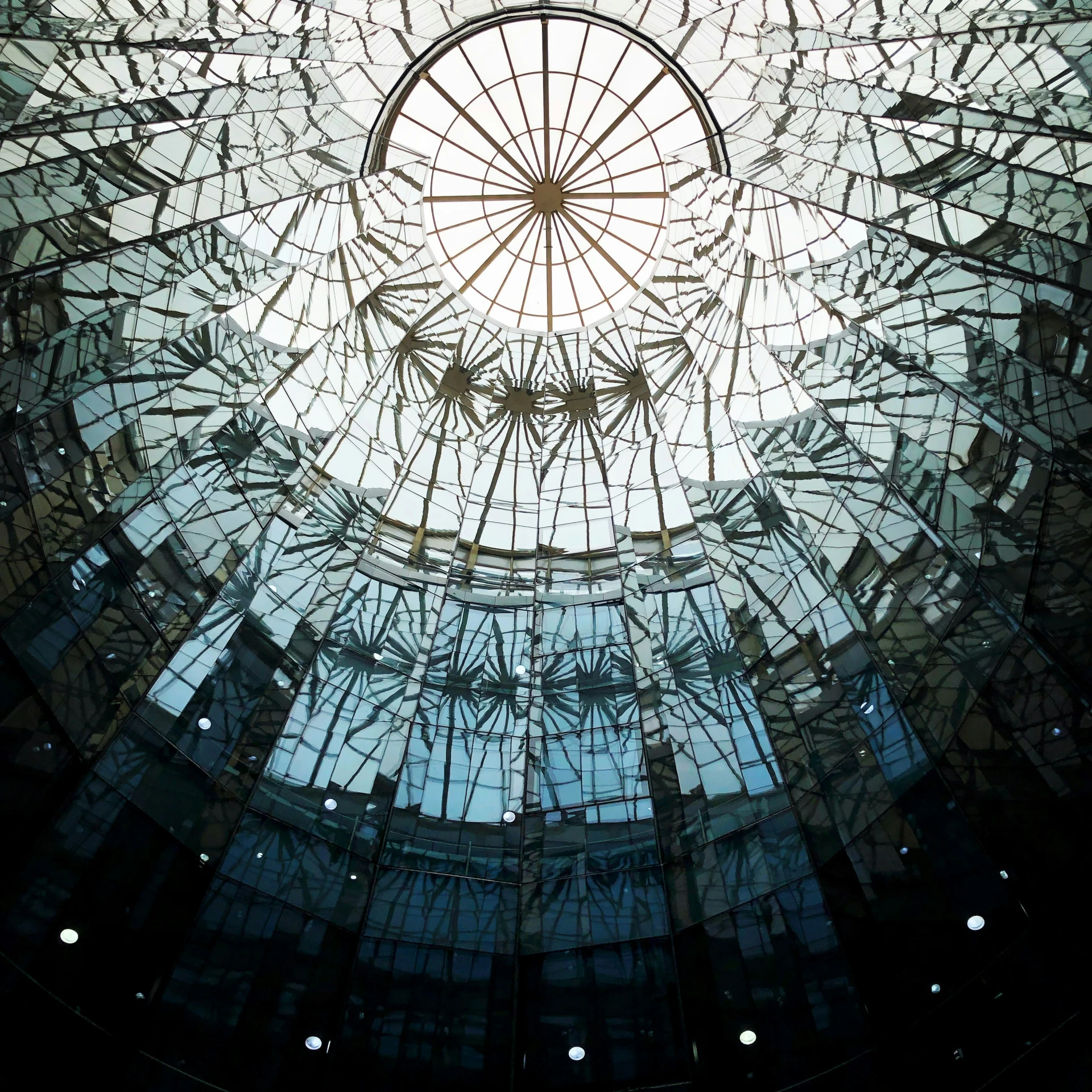 an intricate glass dome with the reflection of other structures