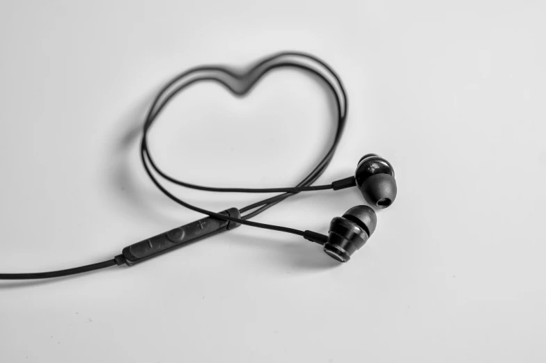 two black ear buds on a white surface