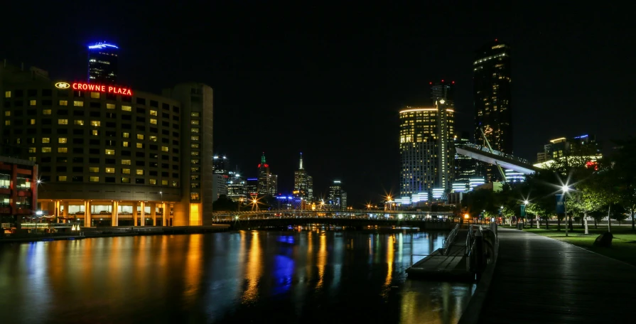 a night view of some buildings that are reflecting in the water