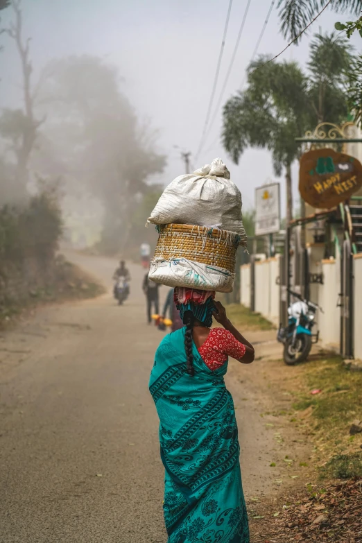 a woman is wearing a hat and carrying a bag