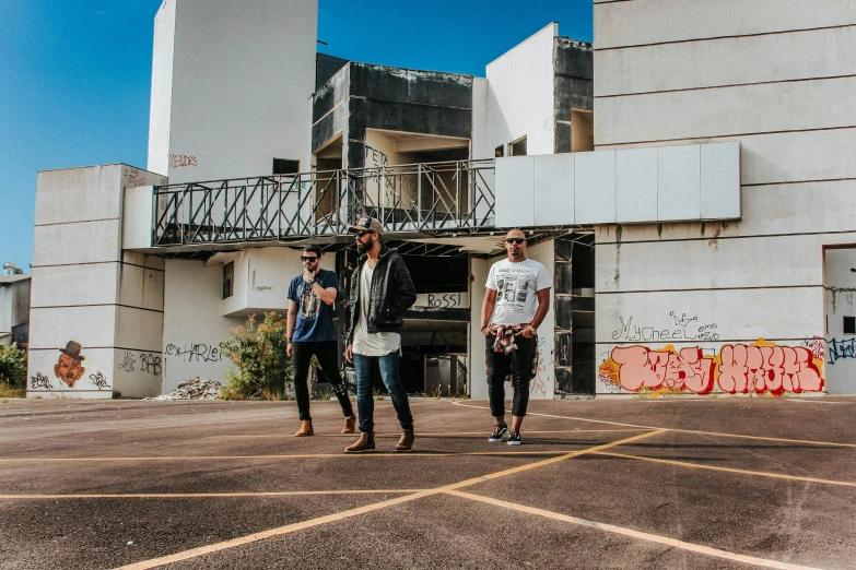 three guys walking outside of a concrete building