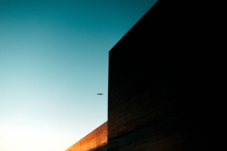 an airplane flies away in the sky above some building